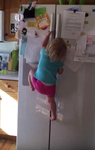 美两岁女童徒手爬冰箱顶展现惊人臂力